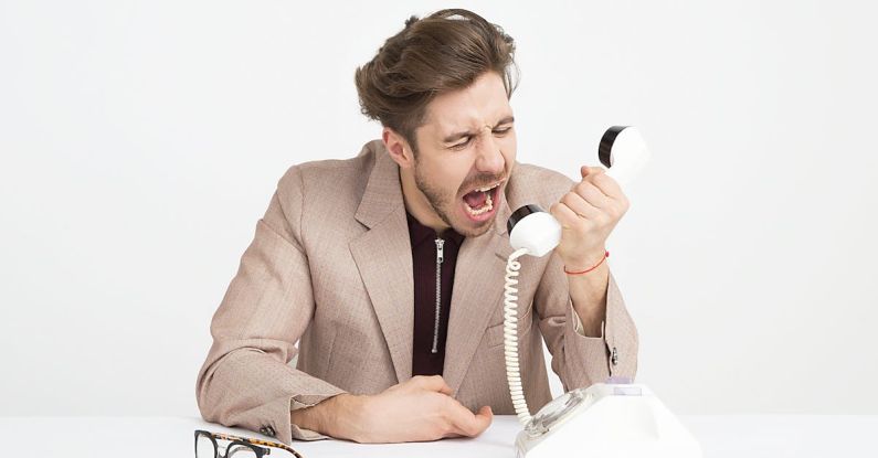 Spam Filters - Man Wearing Brown Suit Jacket Mocking on White Telephone