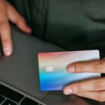 E-Commerce Design - Crop ethnic buyer with plastic card shopping online on laptop